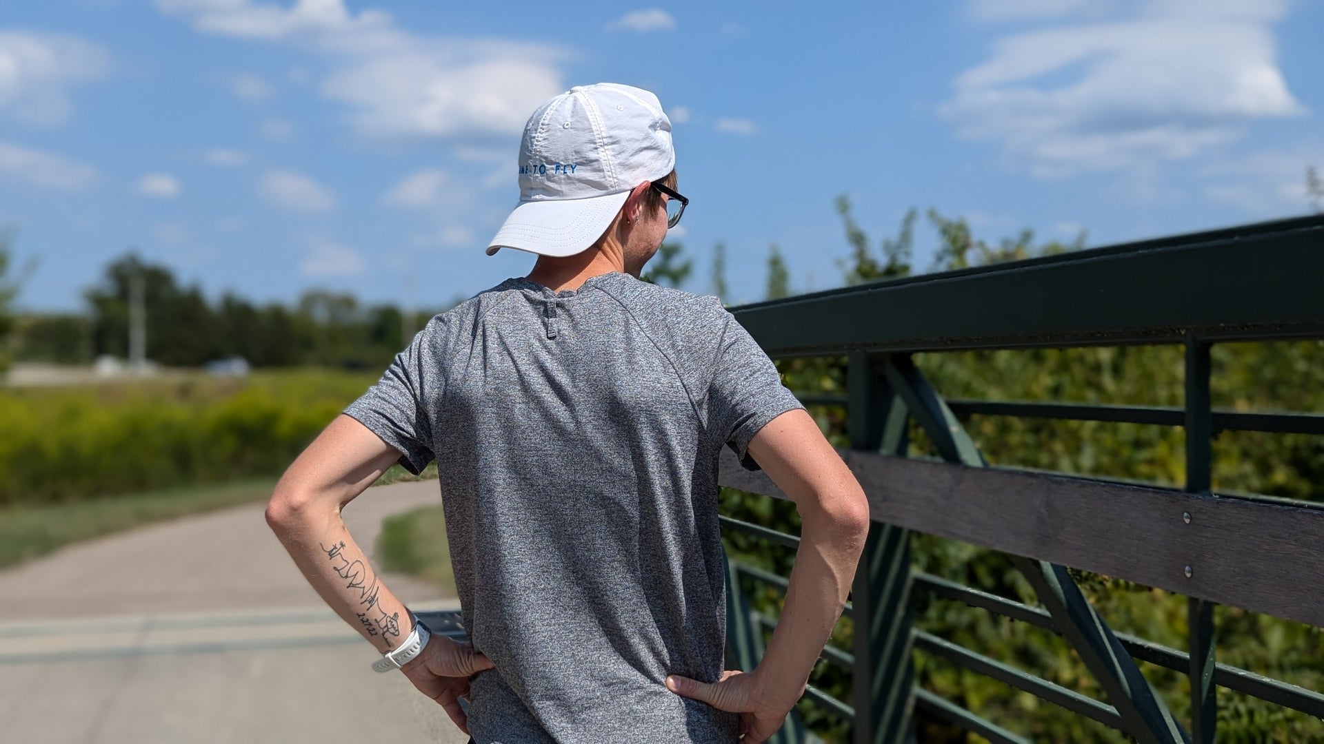 Woman standing on bridge resting from a run.